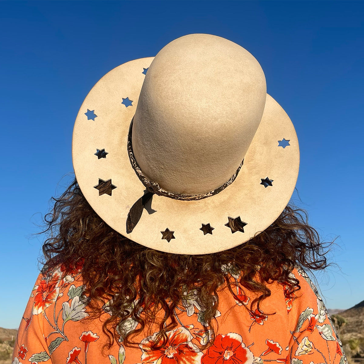 Woman wearing large custom hat with stars cut out